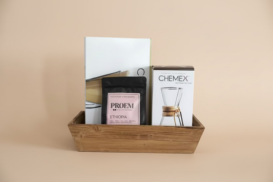 Wooden basket with coffee packaging including a Chemex box and Proem coffee bag.