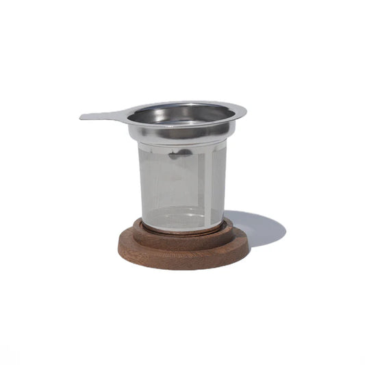 Stainless steel tea infuser with wooden base on a white background
