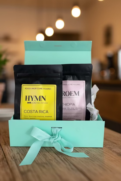 Two coffee bags in a turquoise box with a bow on a beige background