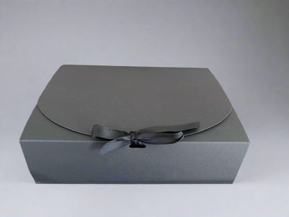 Gray gift box with a black ribbon on a light gray background
